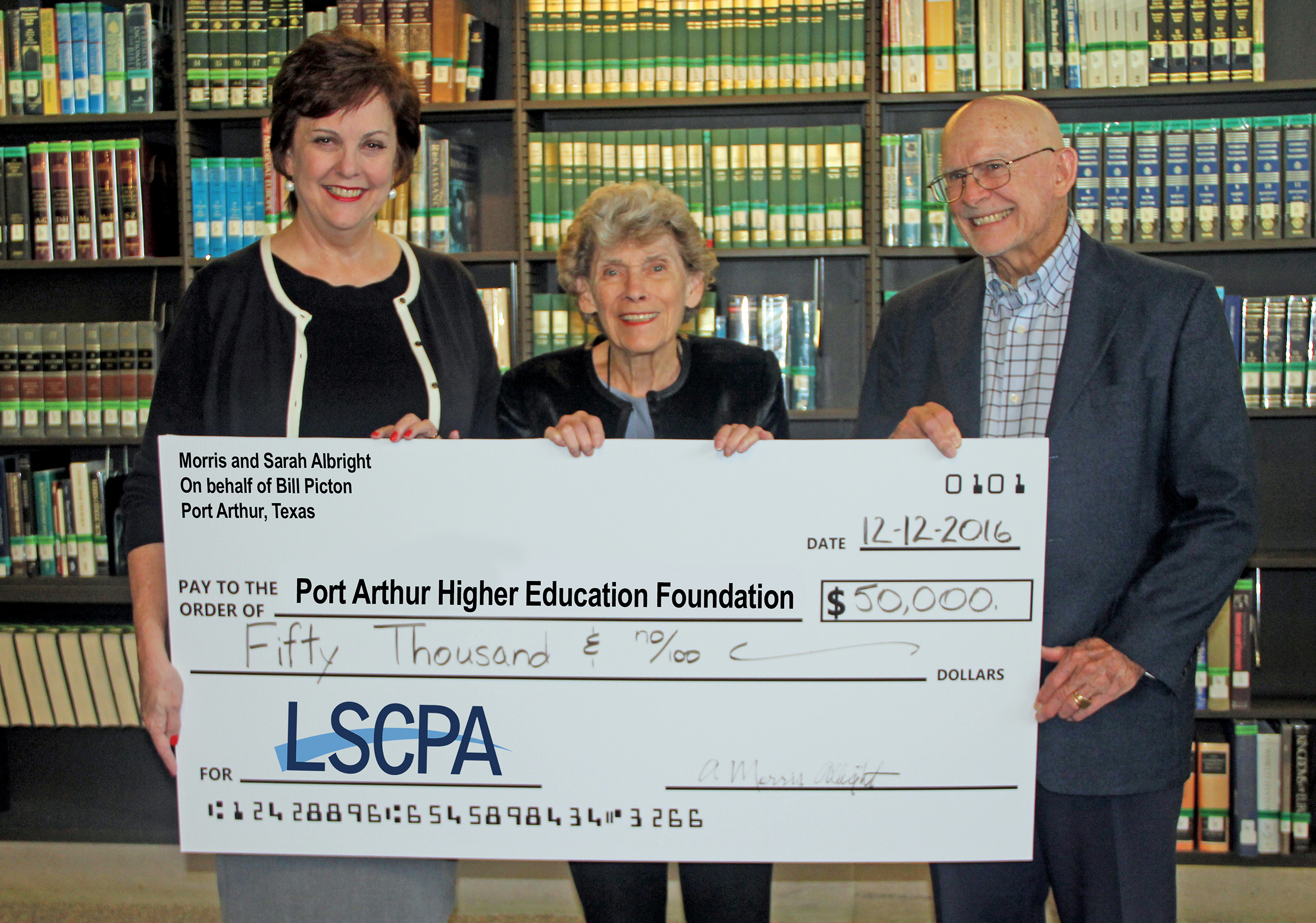 Dr. Reynard, Sarah Albright, and A. Morris Albright standing in library holding a large check to LSCPA in the amount of 50,000