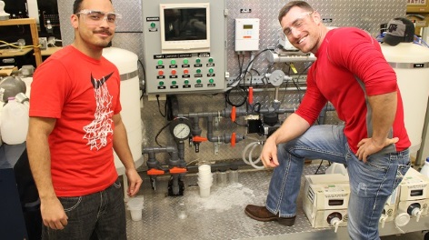 Two students in front of equipment.