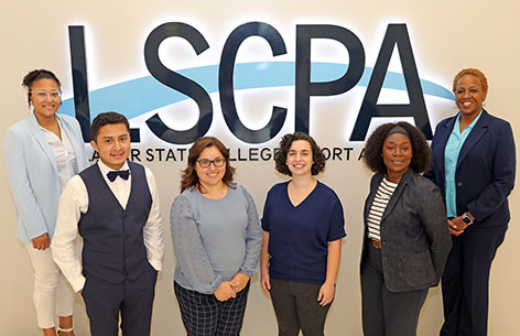 Six Title V department staff members standing in front of LSCPA sign.