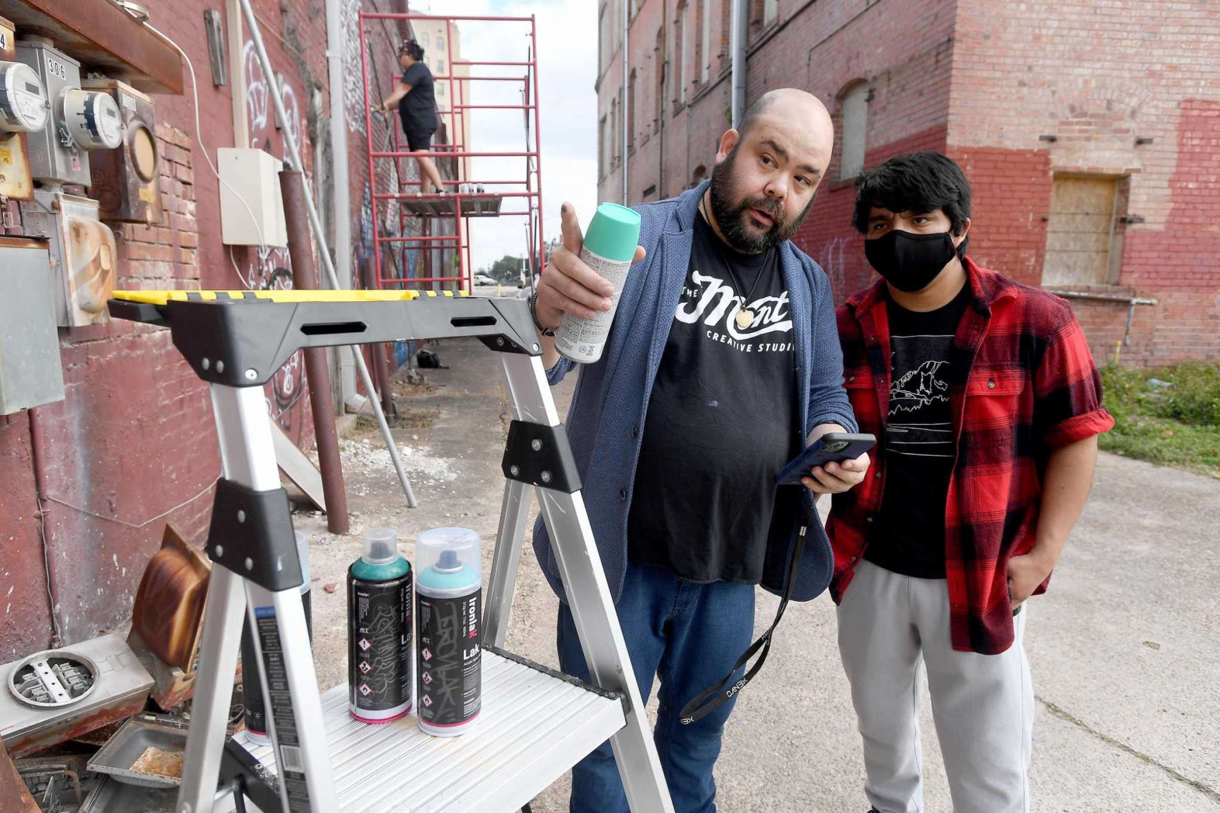 Maurice Abelman offers color choice advice to Alex Pradon as he introduces students in his graphic design classes at Lamar State College Port Arthur to spray paint mural art. Photo made January 2022, Kim Brent/The Enterprise