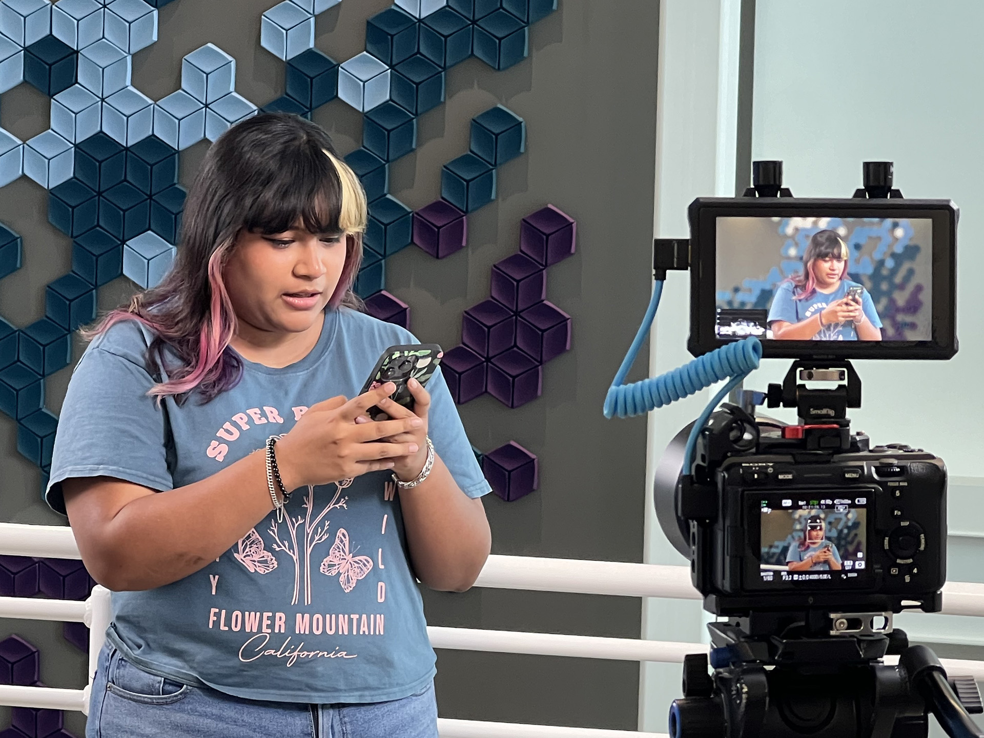LSCPA student looks intently at her phone while posing for a photograph