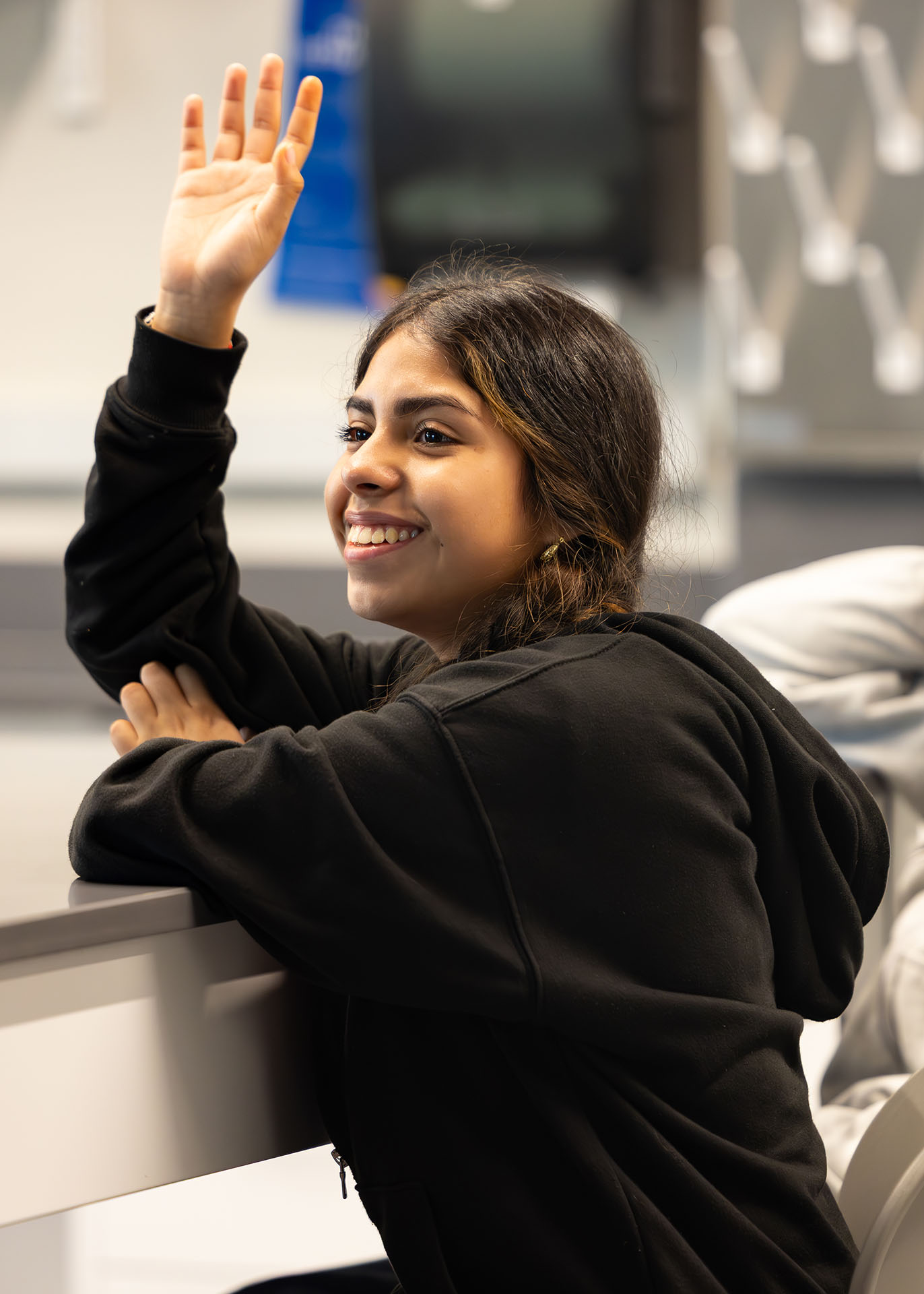 Woman raises her hand in classroom