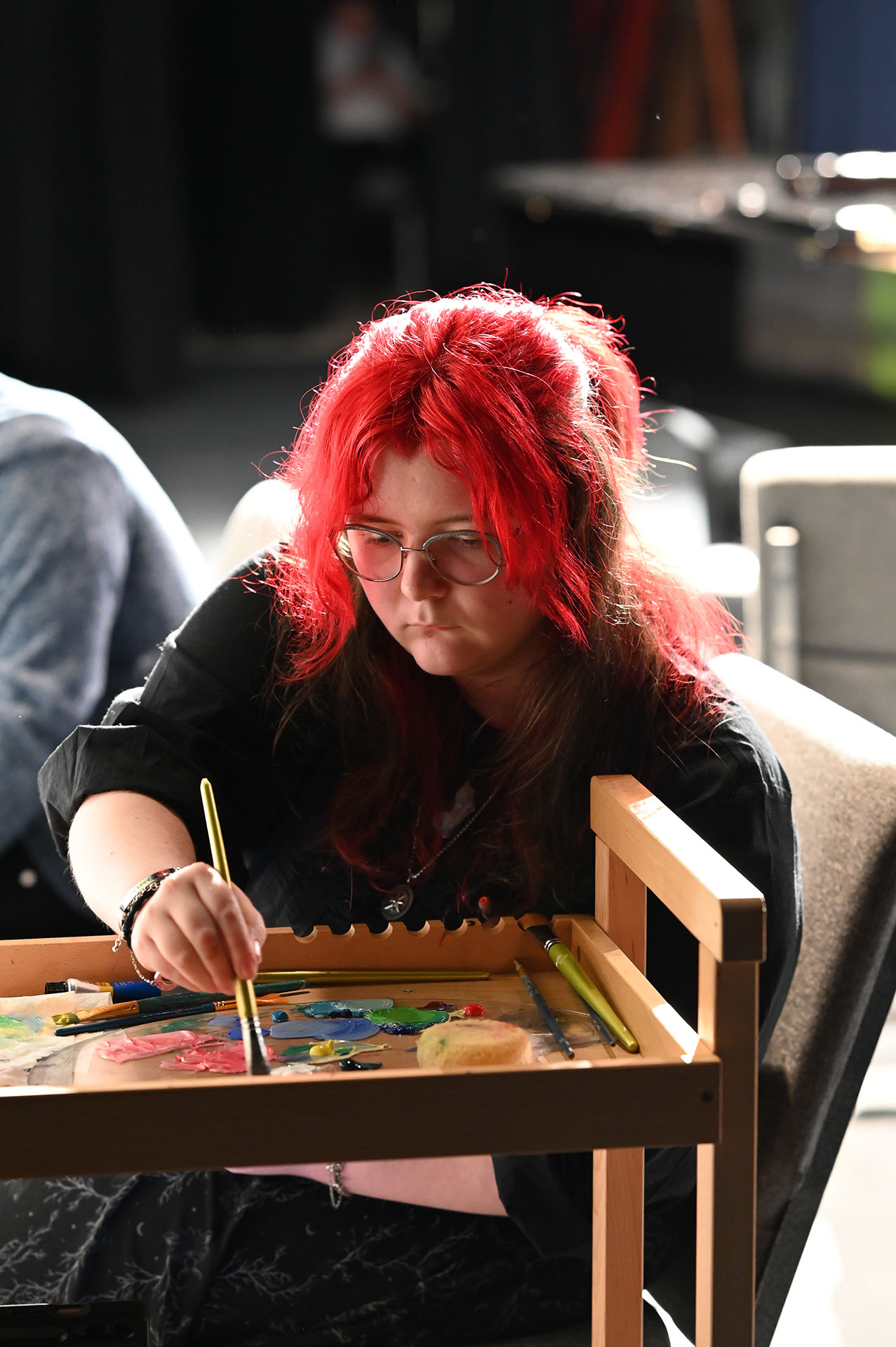 Woman selects paints from palette